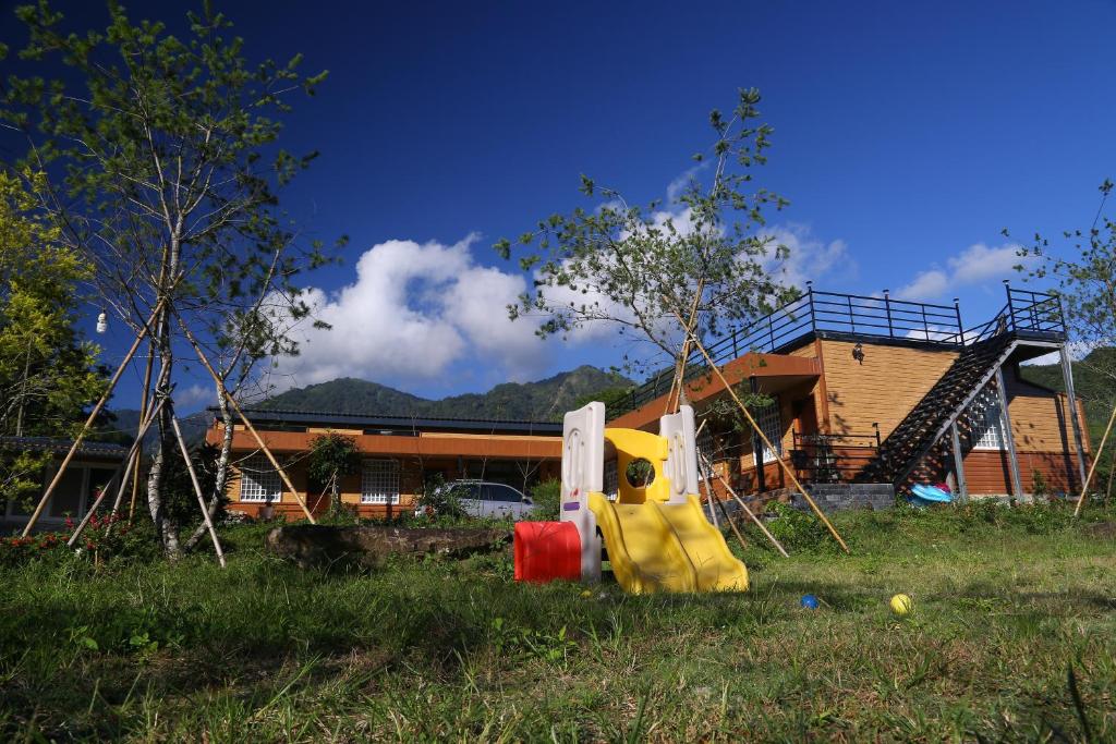 un parque infantil con un tobogán frente a una casa en GO Bill B&B, en Xinyi