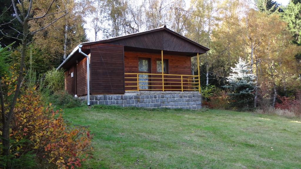 uma pequena cabana de madeira no meio de um campo em osada yukon em Tři Studně