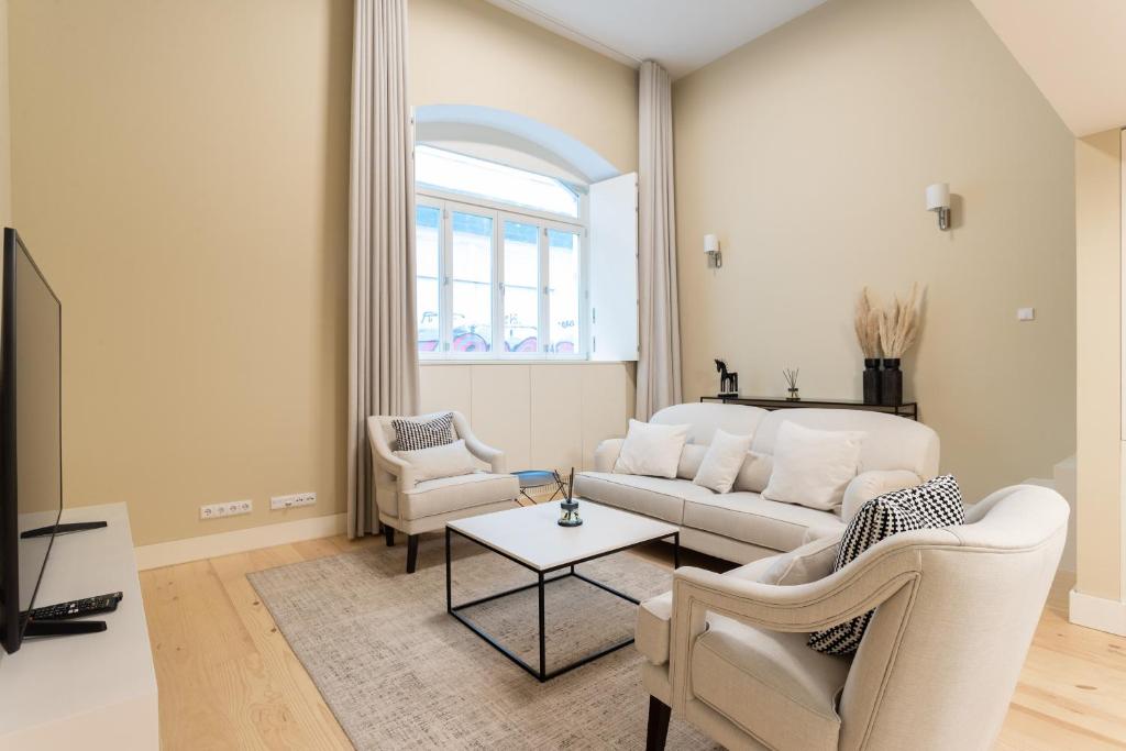 a living room with a white couch and chairs at FLH Cais Sodré Trendy Duplex in Lisbon