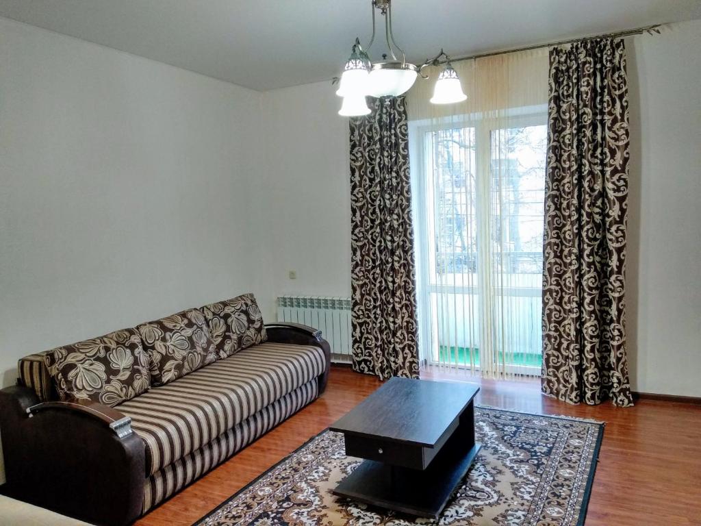 a living room with a couch and a large window at Апартаменти на Ерусалимці 2 кімнати центр поруч з фонтаном Рошен in Vinnytsya