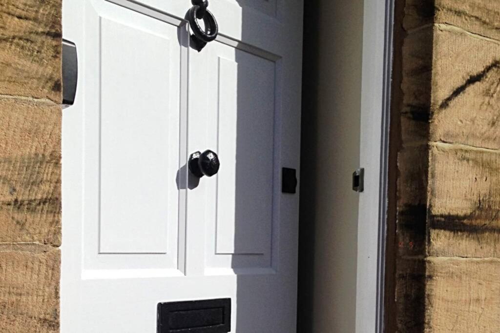 Una puerta blanca con dos luces encima. en Falstaff House, listed building, a delightful late-Georgian holiday cottage in a great location in central Alnwick en Alnwick