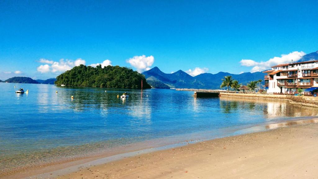 um corpo de água com uma praia e um resort em Angra - Apto Pé na Areia - Bracuhy em Angra dos Reis