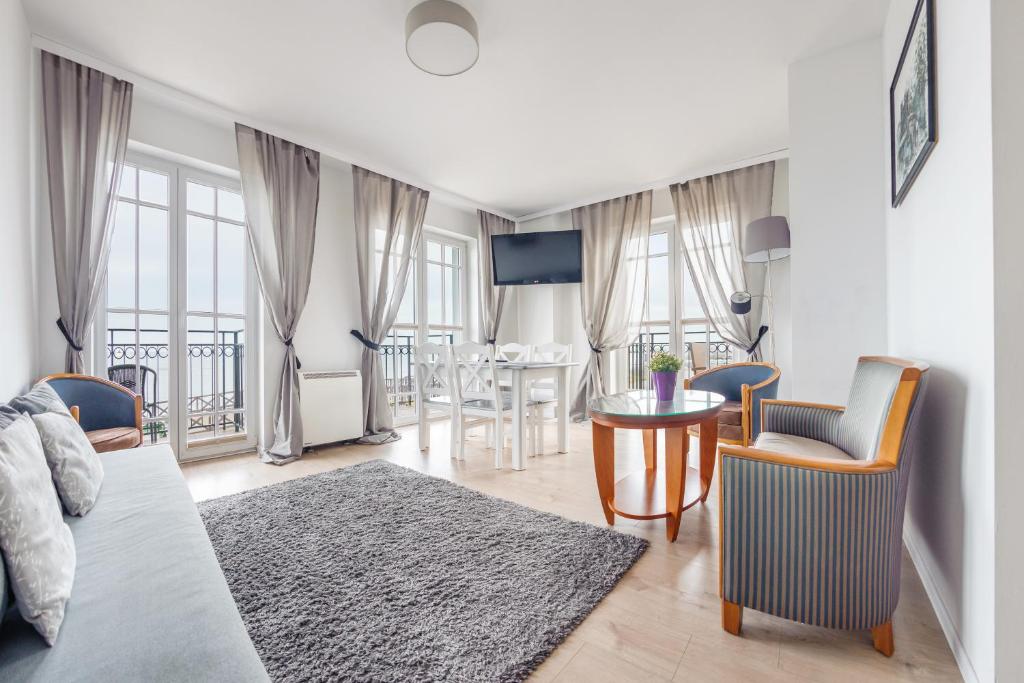 uma sala de estar com uma cama, uma mesa e cadeiras em Apartamenty Sun & Snow Zachód Słońca em Mielno
