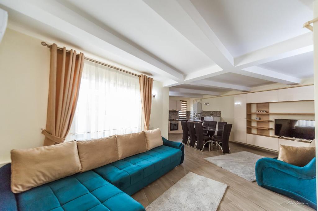 - un salon avec un canapé bleu et une table dans l'établissement Dany Luxury Apartments, à Piteşti
