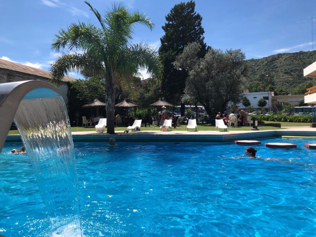 people swimming in a pool with a water fountain at Riviera Hotel & Spa in Villa Carlos Paz