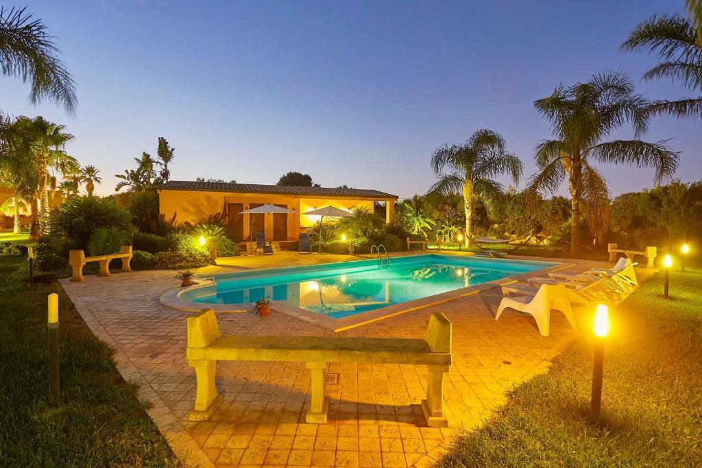 a swimming pool in front of a house at Scent Selinunte Garden in Castelvetrano Selinunte