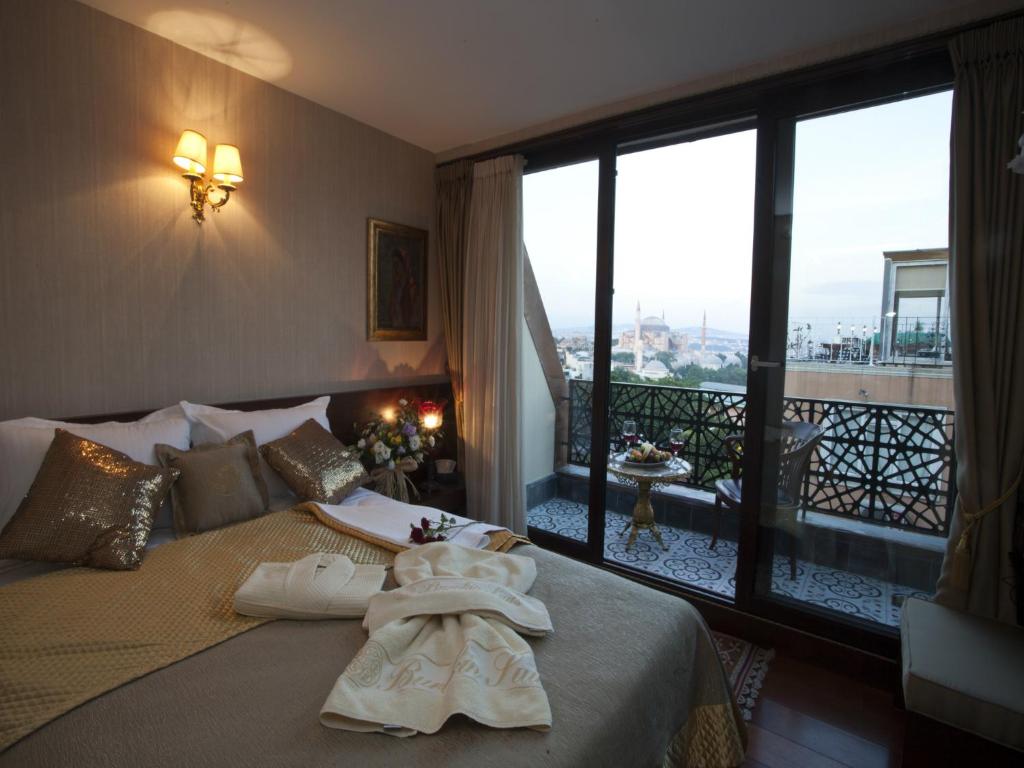 a hotel room with a bed, table and window at Burckin Hotel in Istanbul