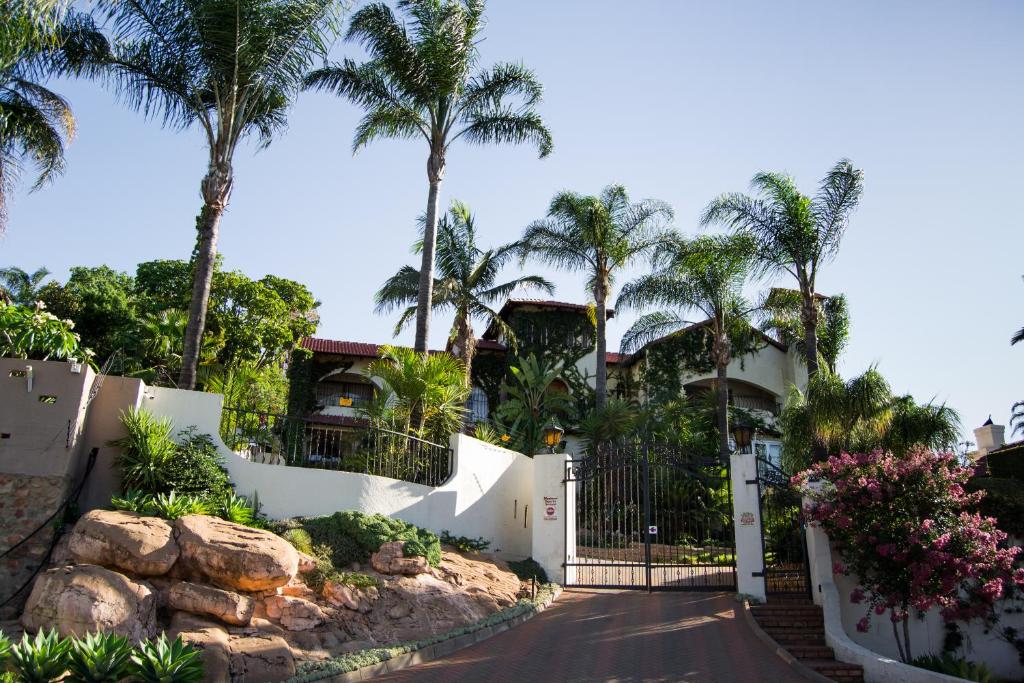 une maison avec des palmiers et une allée dans l'établissement Casa de Ross, à Pretoria