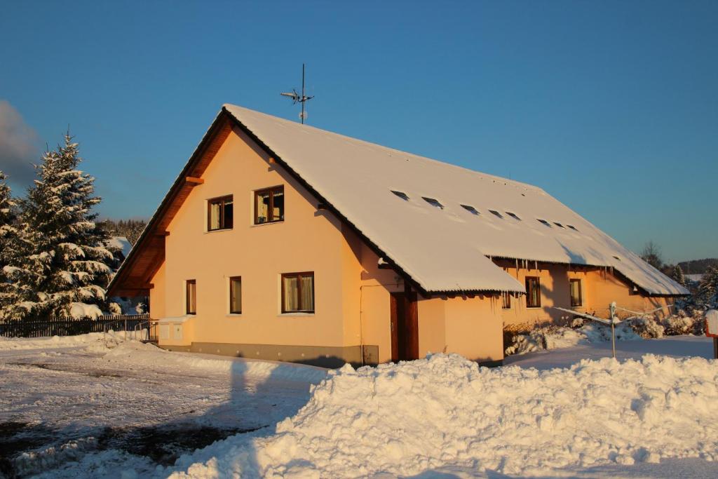 ein schneebedecktes Haus mit einem Schneehaufen in der Unterkunft Penzion Kitty in Lučany nad Nisou