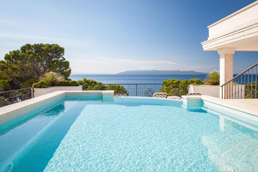 a swimming pool with a view of the ocean at Luxury Rooms Villa Jadranka in Makarska