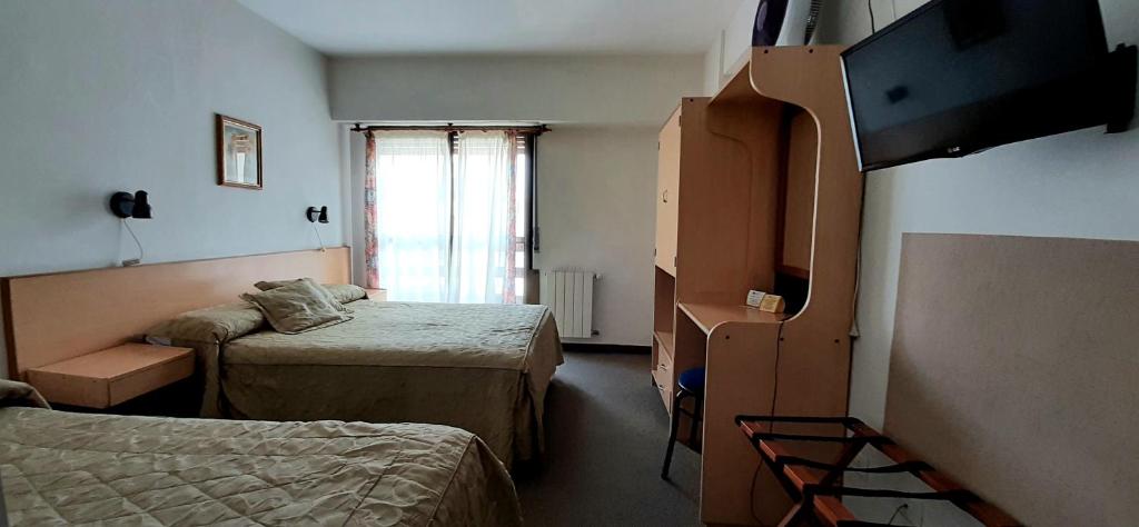 ein kleines Zimmer mit zwei Betten und einem Fenster in der Unterkunft Patagonia Apart Hotel in Puerto Madryn