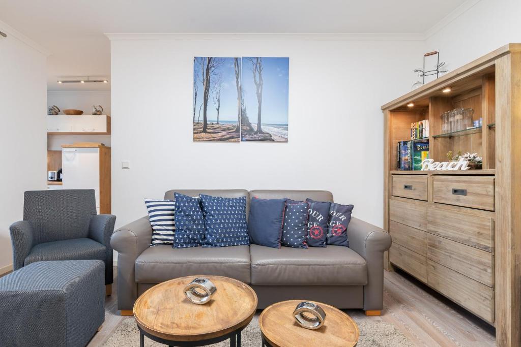 una sala de estar con un sofá y una mesa en Haus Pamir - Ferienwohnungen, en Ostseebad Nienhagen