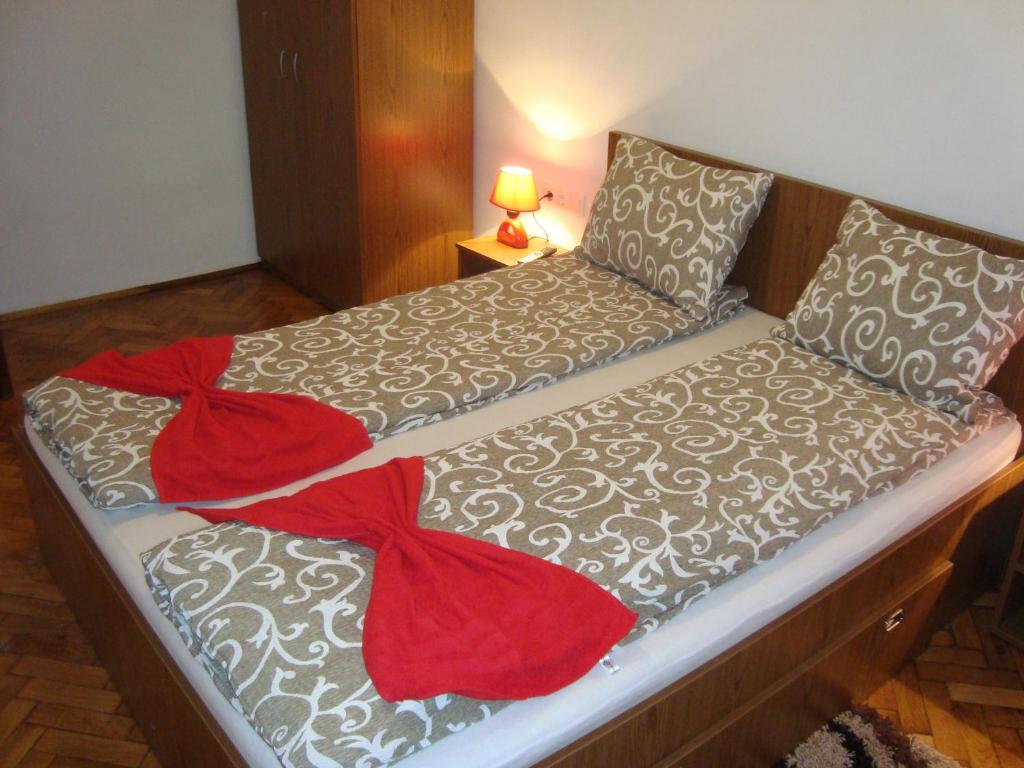 1 cama con manta roja y almohadas en Apartament Miruna Sibiu Filarmonicii, en Sibiu