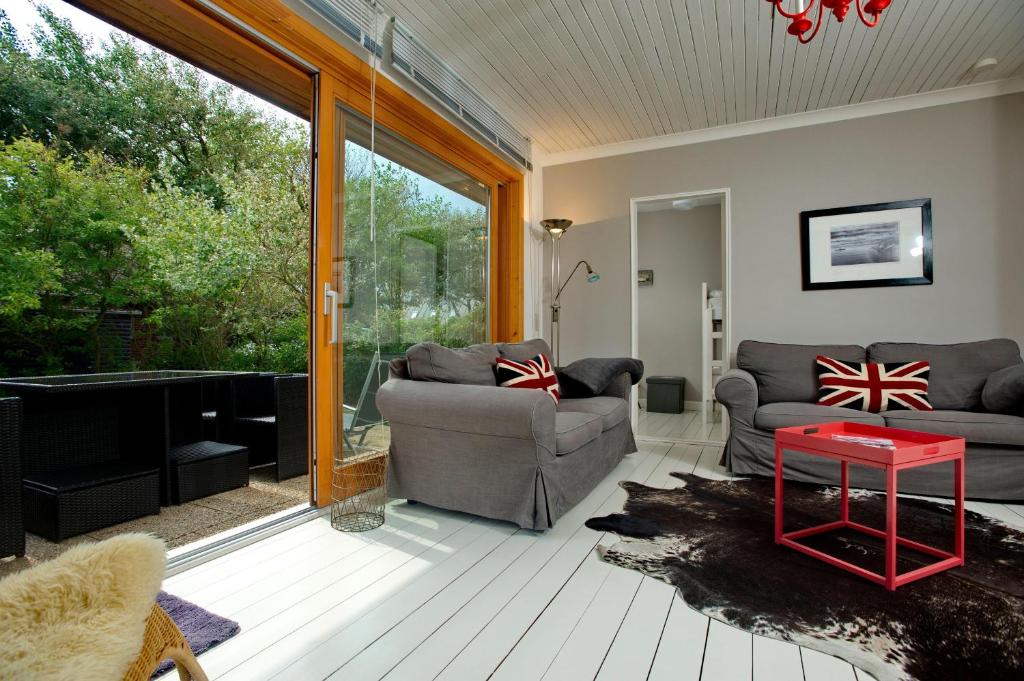 una sala de estar con un sofá y una mesa en Bungalow-L, en Westerland