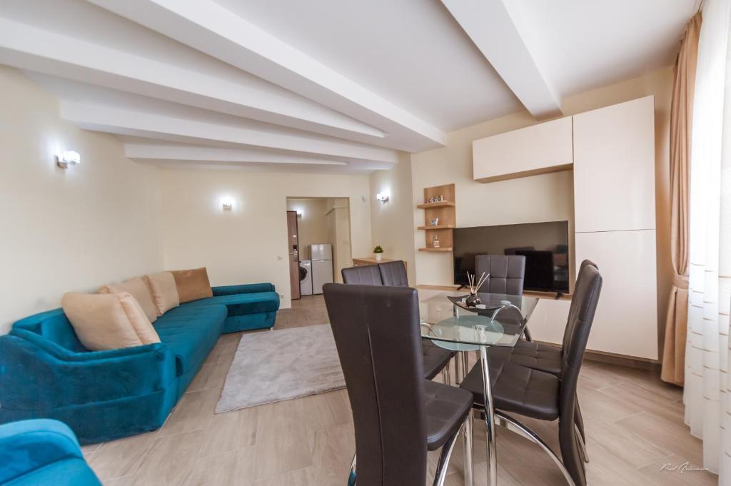 un salon avec un canapé bleu et une table en verre dans l'établissement Luxury Desing Apartment, à Piteşti