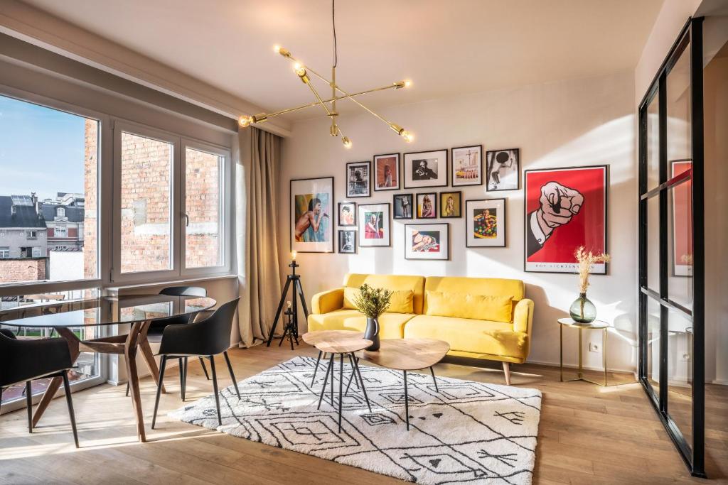 - un salon avec un canapé jaune et une table dans l'établissement Mini loft 1 bedroom 2 steps from Av Louise, à Bruxelles