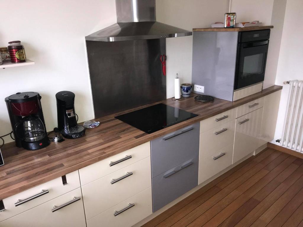 a kitchen with white cabinets and a stove top oven at Suite Clémenceau 82 in Reims