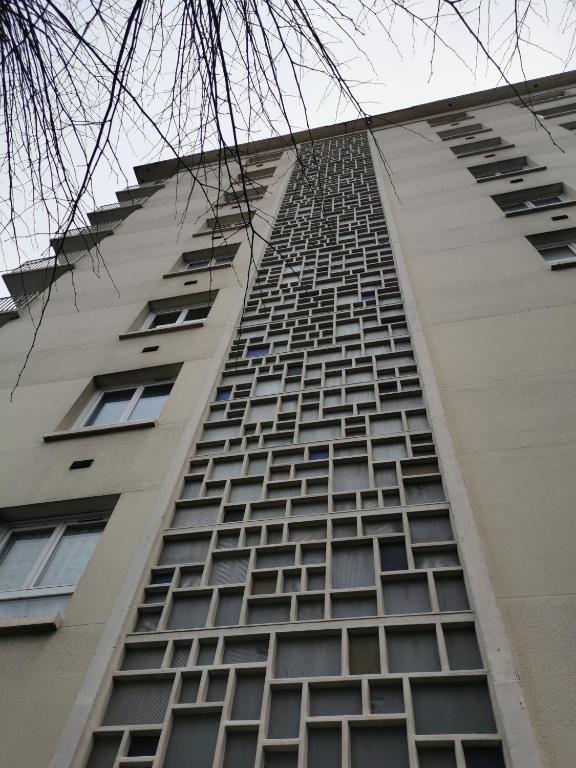 a tall building with many windows on the side of it at Suite Clémenceau 82 in Reims