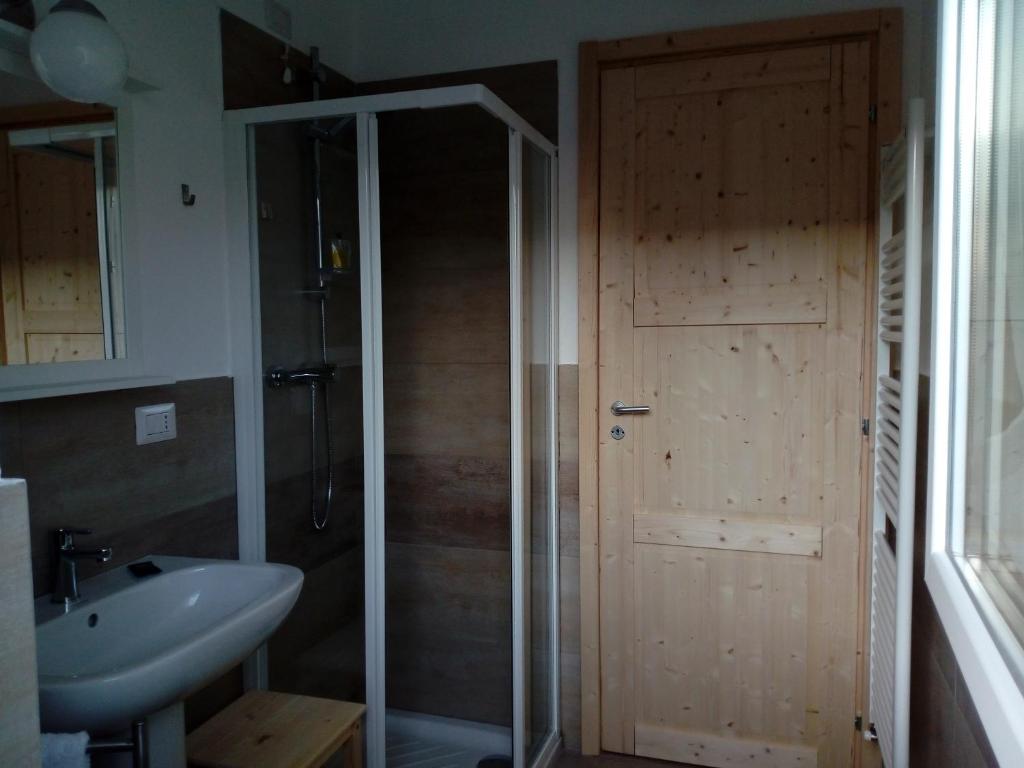 a bathroom with a shower and a sink and a door at Casa Maria in Cantù