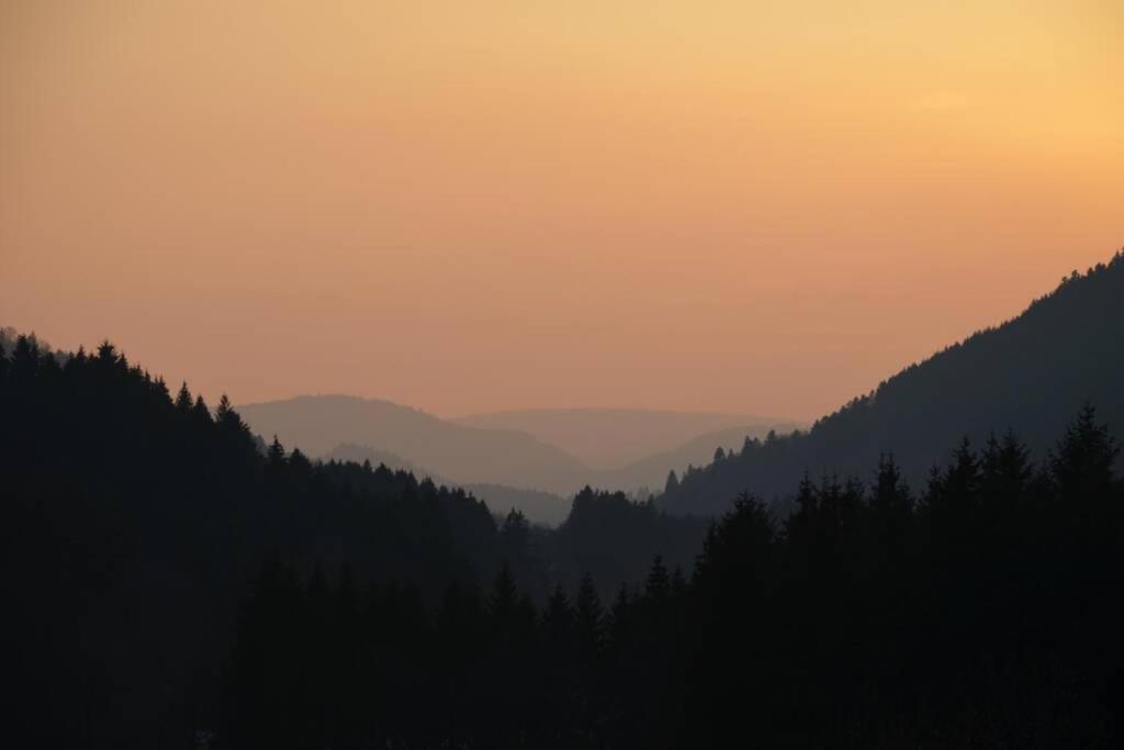 a view of a mountain at sunset with trees at gîte de la cheneau in Rochesson