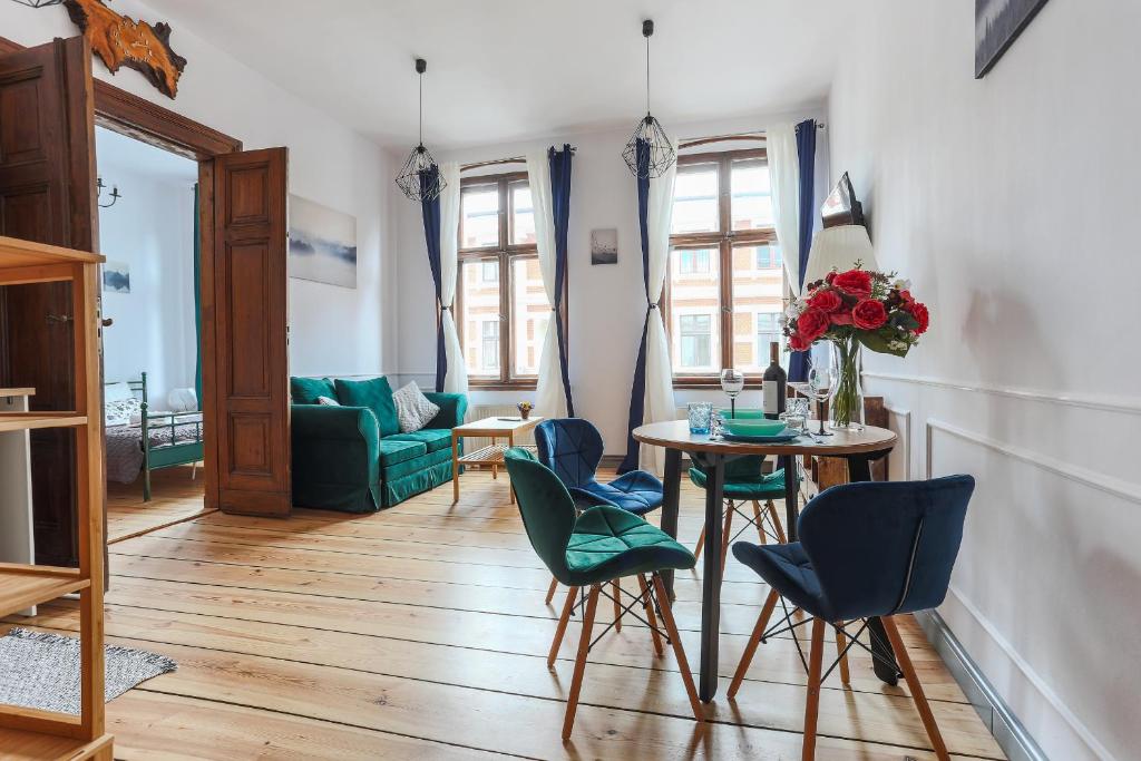 uma sala de estar com mesa e cadeiras em Best 2 Rest Apartment em Toruń