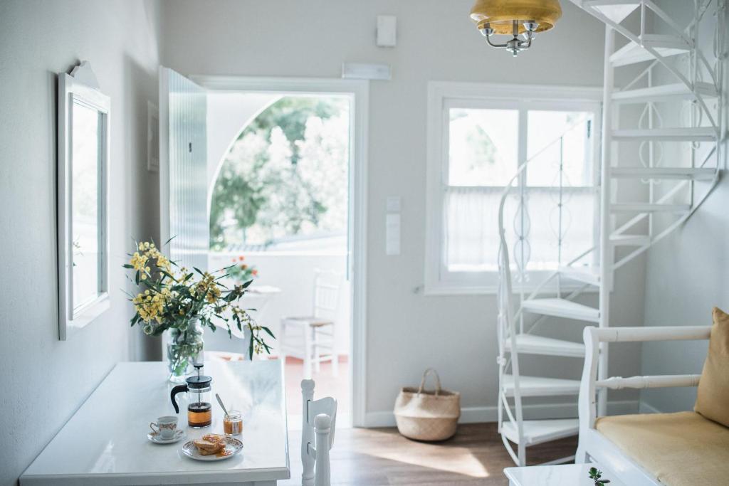 ein Wohnzimmer mit einer Treppe und einem Tisch mit Blumen in der Unterkunft Odyssey Suites in Poros