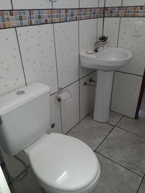 y baño con aseo blanco y lavamanos. en Alojamiento 1 Lili y Víctor en Puerto Iguazú