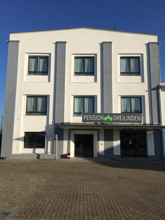 a white building with a sign in front of it at Pension Dreilinden Hannover GmbH in Hannover