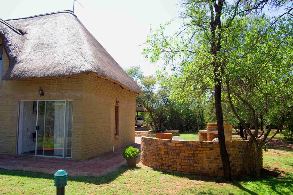 a small brick building with a tree next to it at Suzie's Loft - NUDE - SunEden Family Naturist Resort in Pretoria