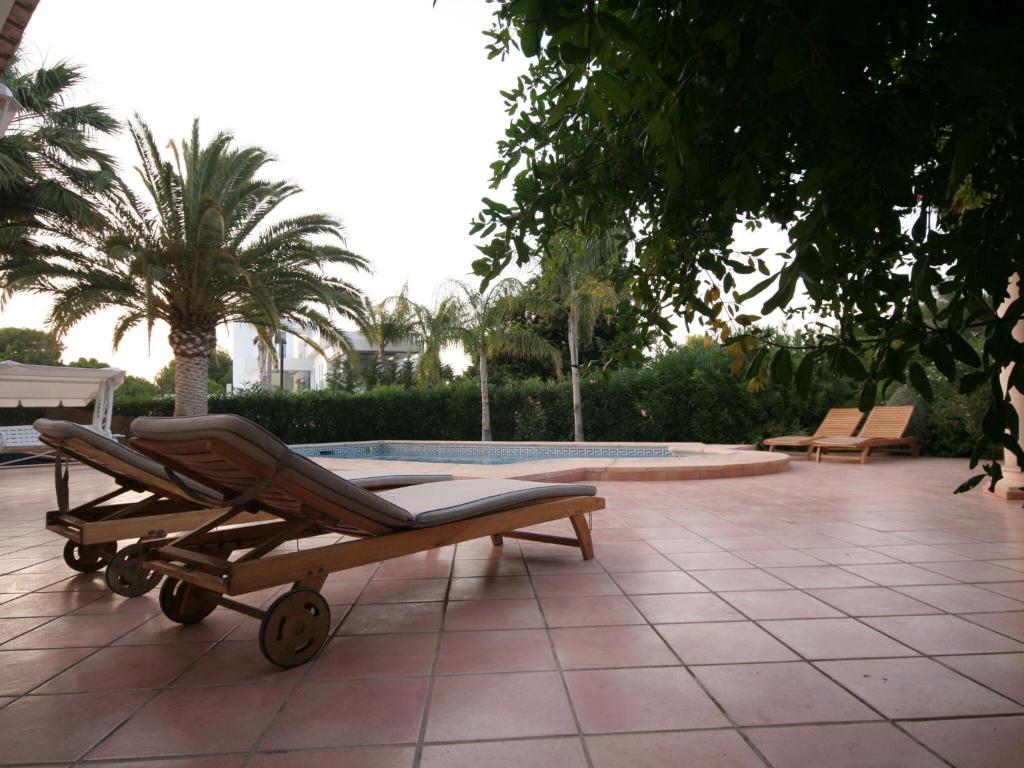 une chaise longue à côté de la piscine dans l'établissement Belvilla by OYO Somontes, à Dénia