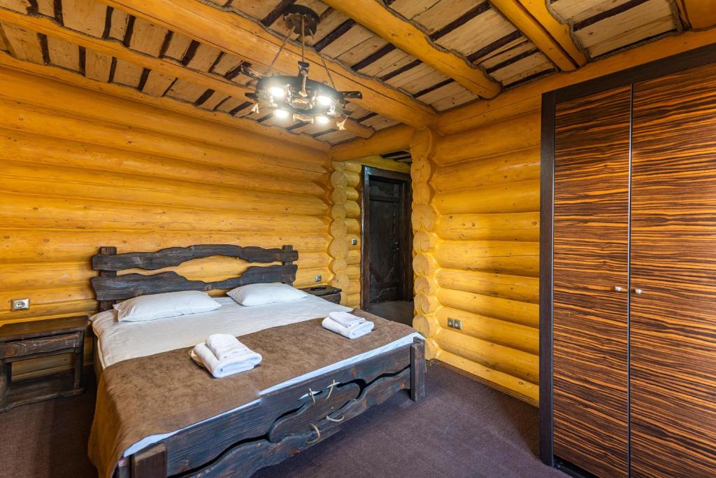 a bedroom with a bed in a log cabin at Eco Hotel Bungalo in Bukovel