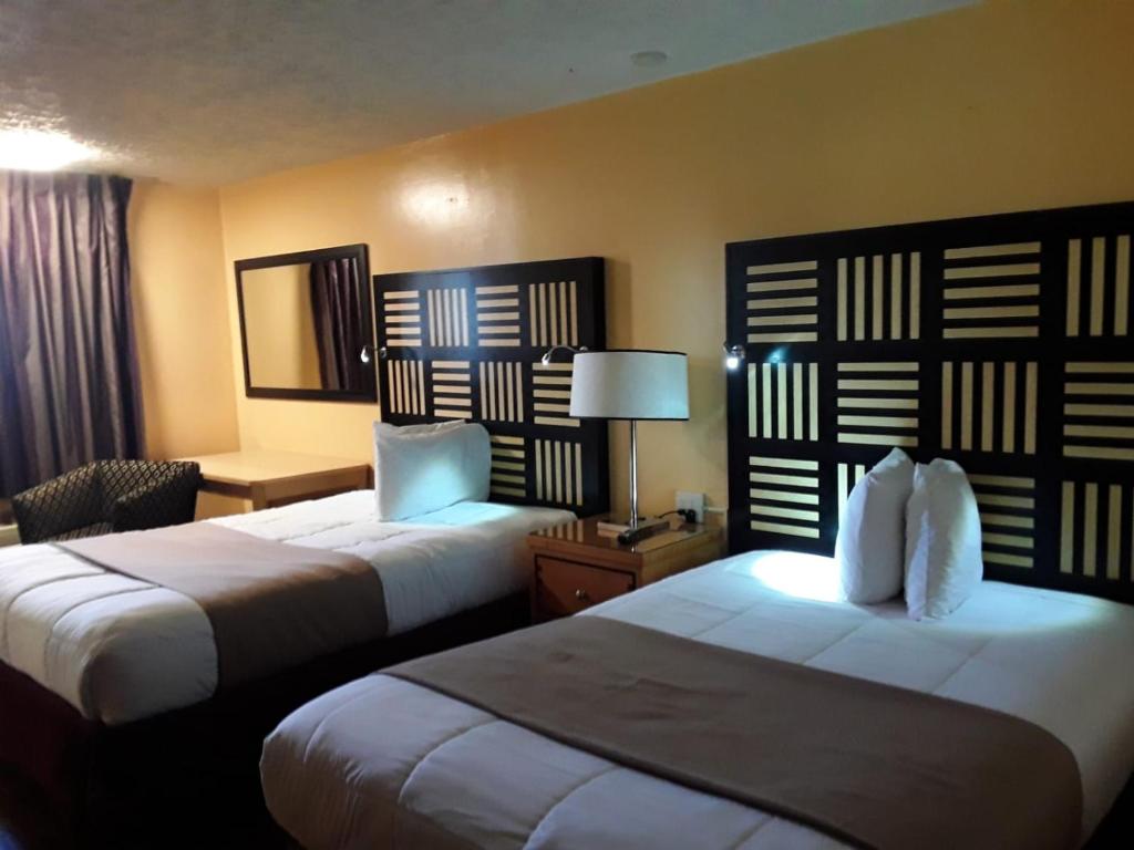 a hotel room with two beds and a lamp at Motel M Lewisburg in Lewisburg