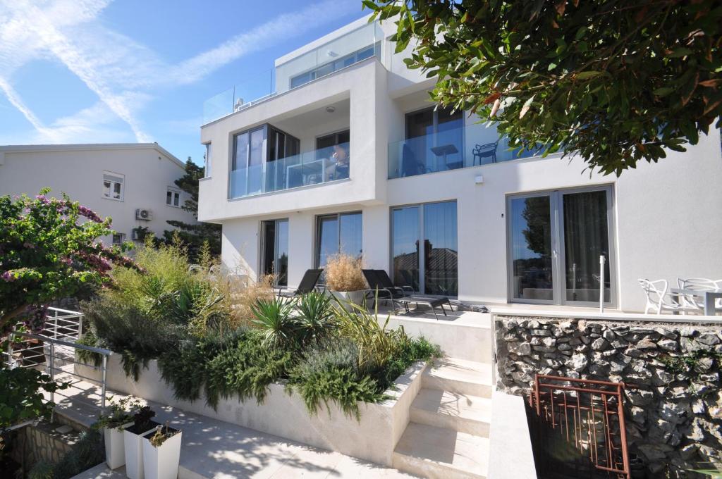 a large white house with glass windows at Design apartments 3&4 in Mali Lošinj