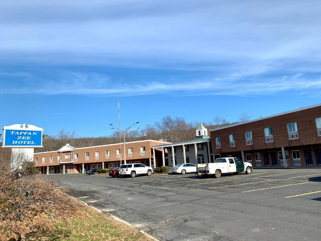 un estacionamiento con autos estacionados frente a un edificio en Tappan Zee Hotel, en West Nyack