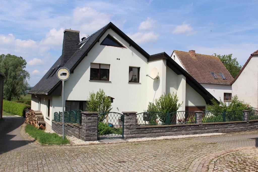 ein weißes Haus mit schwarzem Dach in der Unterkunft Ferienwohnung am Fluss in Weischütz