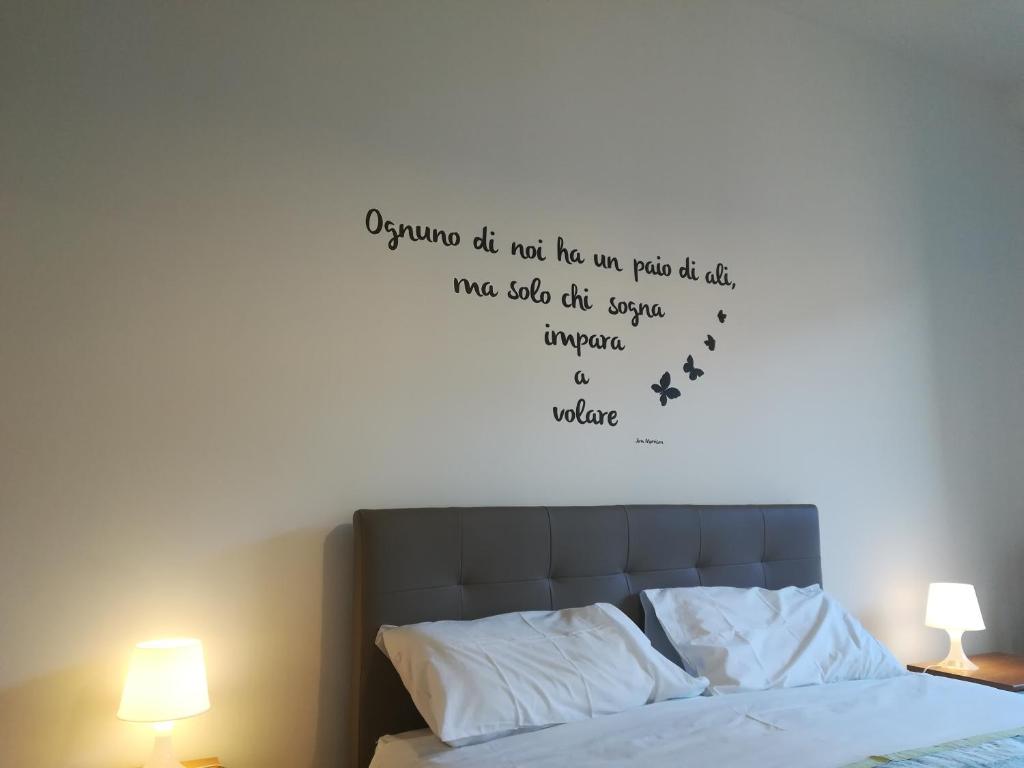 een slaapkamer met een bed met een citaat aan de muur bij lingotto turin apartament in Turijn