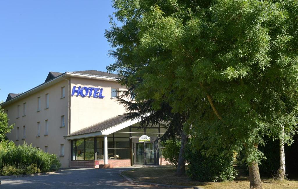 un edificio Ford con un árbol delante de él en The Originals City, Le Clos de l'Orgerie, Laval Sud (Inter-Hotel), en Château-Gontier