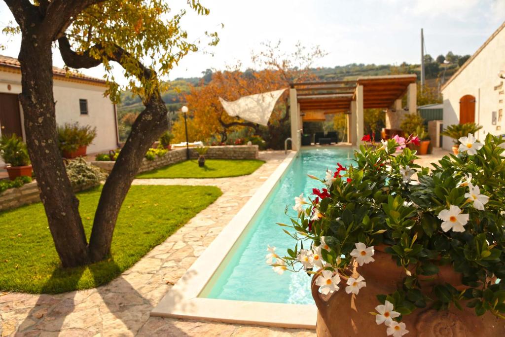 - une piscine dans une cour fleurie dans l'établissement Villa Angiolina, Molise, à Guglionesi
