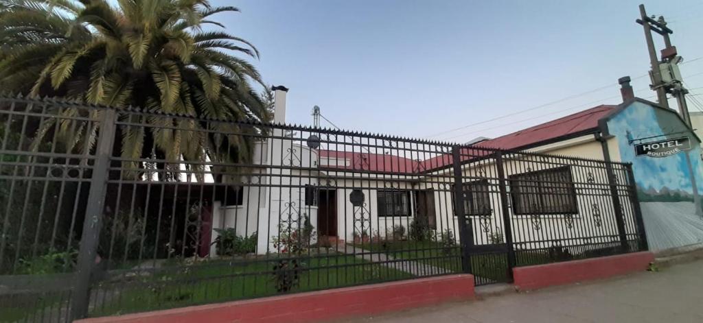 une clôture devant un bâtiment avec un palmier dans l'établissement Hotel Boutique Molino Viejo, à San Carlos