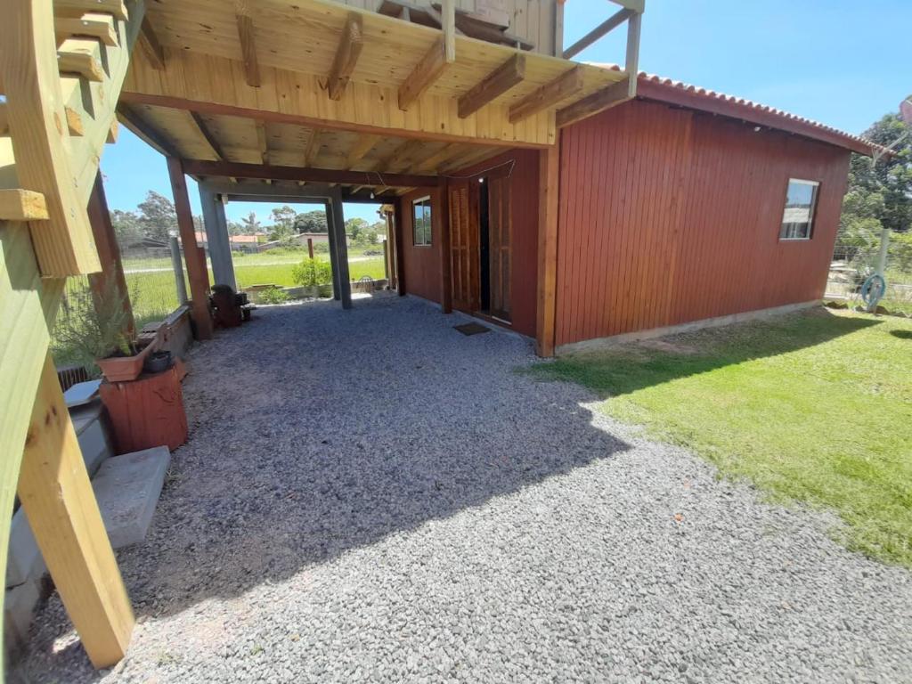 a garage with a wooden building with a porch at Casa completa Praia do Rosa Praia do Ouvidor in Garopaba