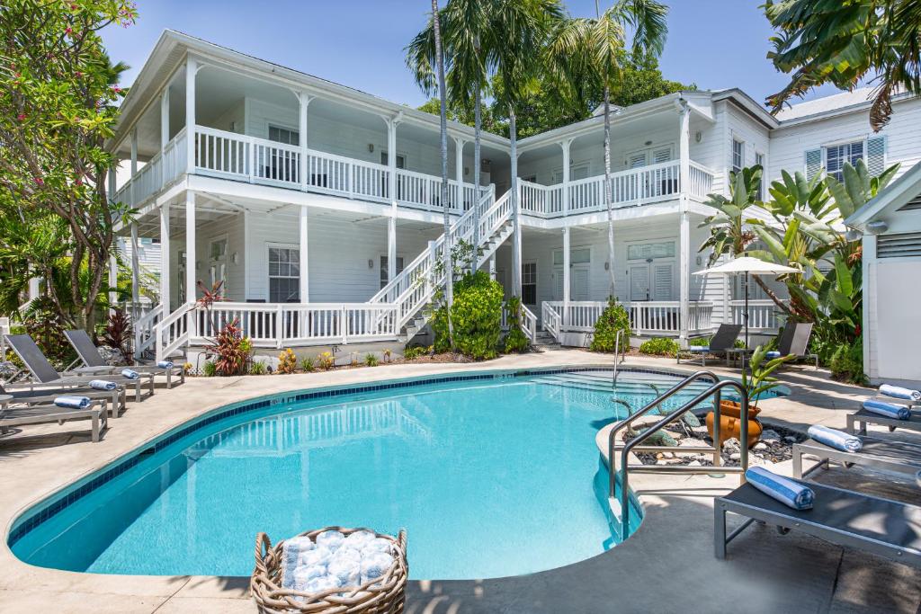 a large white house with a swimming pool in front of it at Paradise Inn - Adult Exclusive in Key West