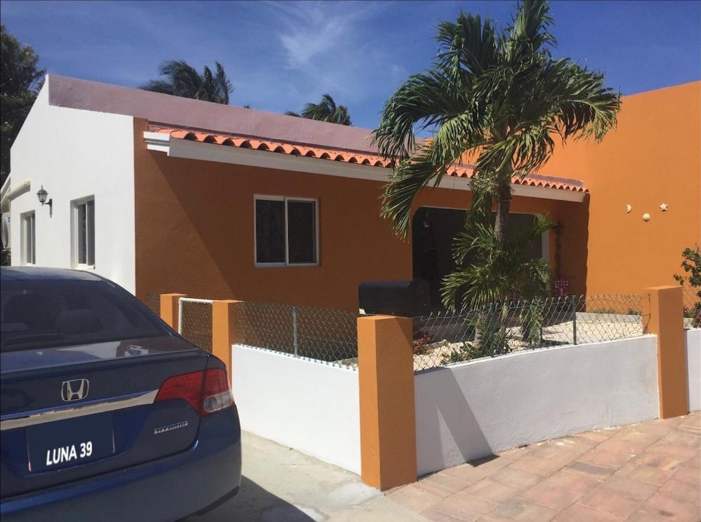 un coche aparcado frente a una casa en Luna 39, en Oranjestad