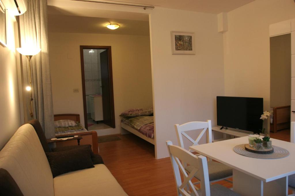 a living room with a couch and a table and a television at STUDIO APARTMAN MARIA in Čavle
