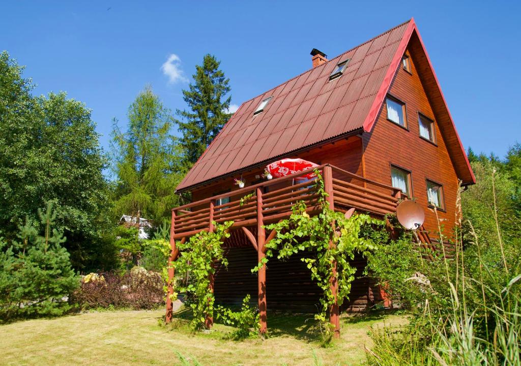 een huis met een rood dak en wijnstokken bij Dom CROCUS z ogrodem w Parku Krajobrazowym in Brenna