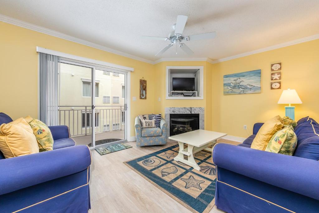 a living room with two blue couches and a fireplace at Sunset Bay 309 in Ocean City