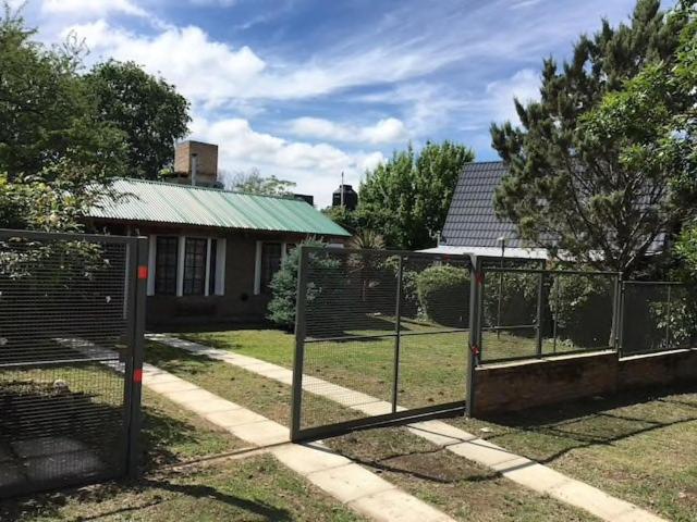 una cerca frente a una casa con un patio en Santa Rosa con parque y rio Ideal para familias en Santa Rosa de Calamuchita