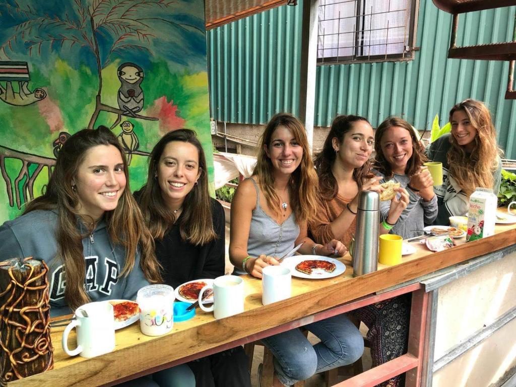 a group of women sitting at a table eating food at Mi Casa Tica Backpackers in Monteverde Costa Rica