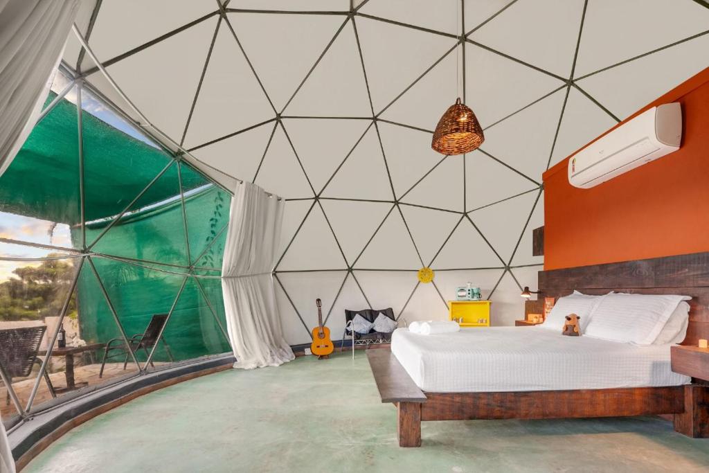 um quarto com uma cama numa tenda em Glamping Serra da Canastra - Casinha de Hortelã - Domo Jaboticaba em Delfinópolis