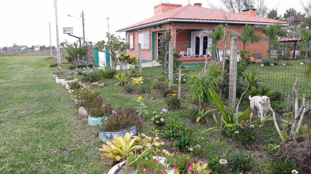 a garden in front of a house with plants at Casa de Praia para veraneio - temporada Balneário Gaivotas-SC Família Kunhasky in Balneário Gaivotas