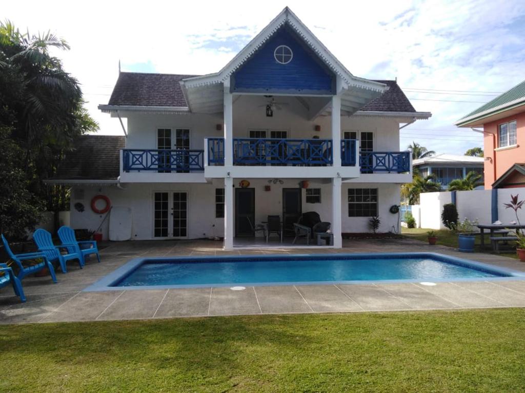 a house with a swimming pool in front of it at C & A Seashell Villa in Bon Accord Village